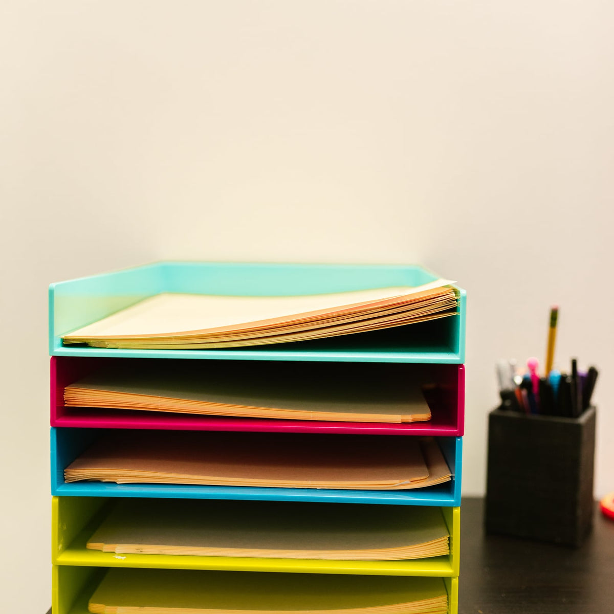 Modular desk tray with stacked documents on an office desk