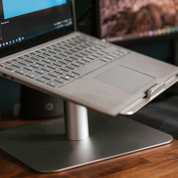 Aluminium laptop stand raising a laptop on a desk